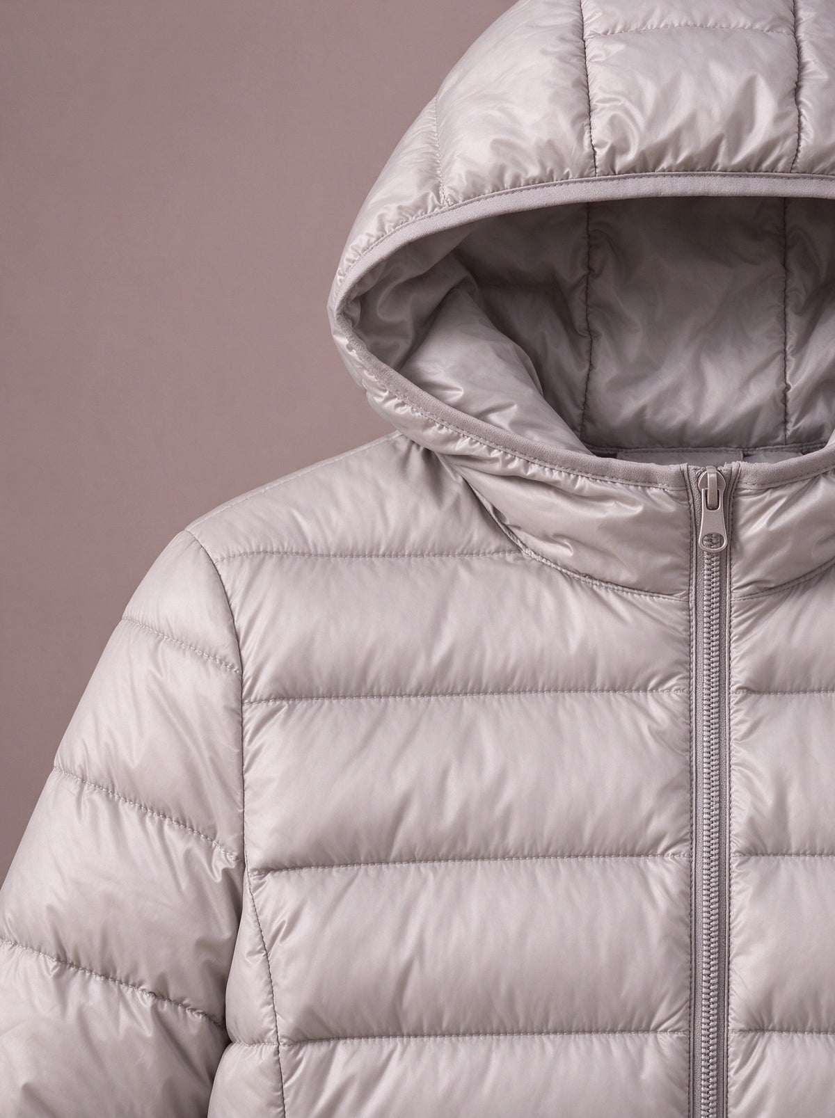 Attached hood and narrow quilting of the grey light down jacket, close view