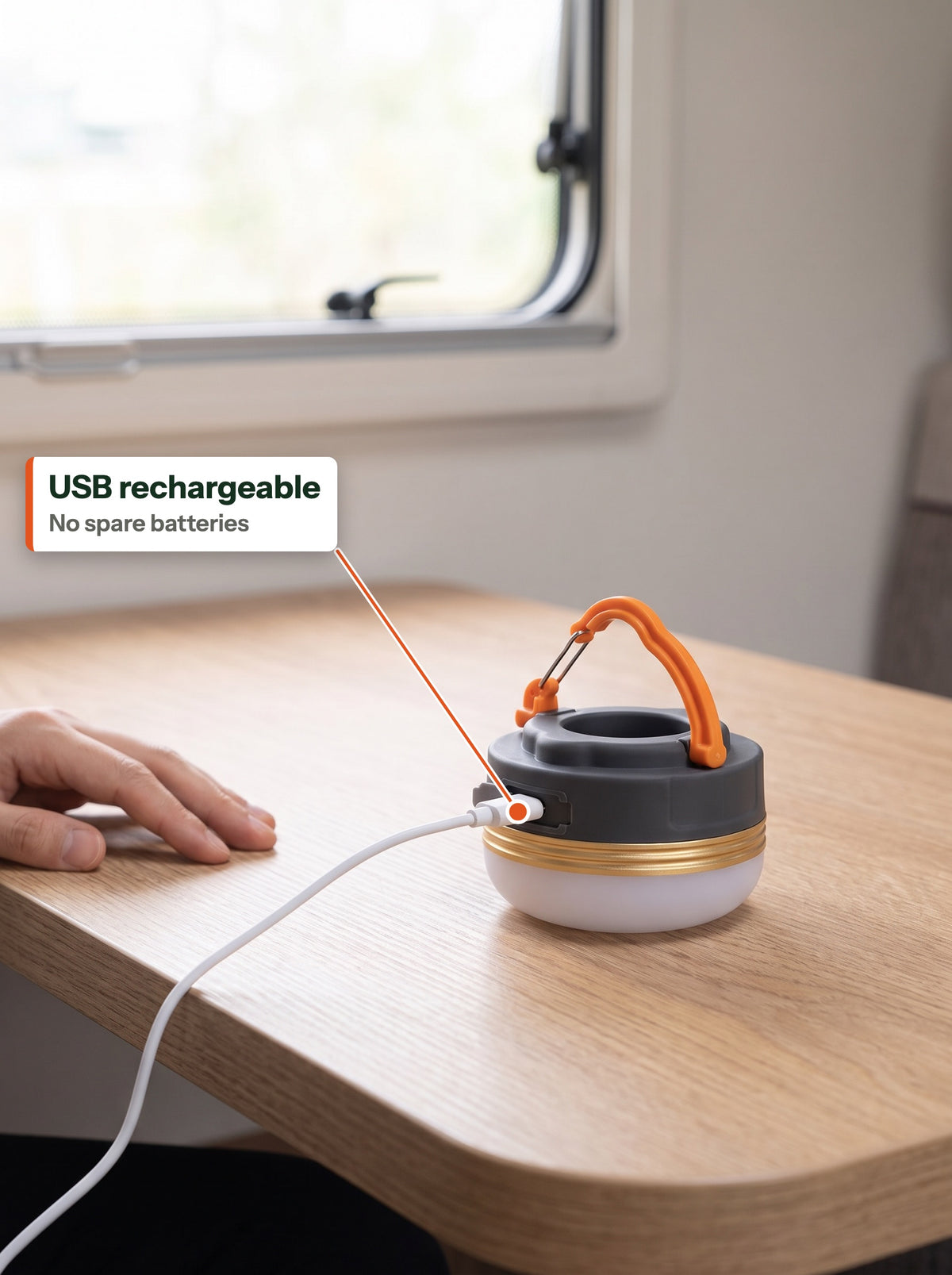 Camp lantern charging over a USB cable on a camper table (EN label)