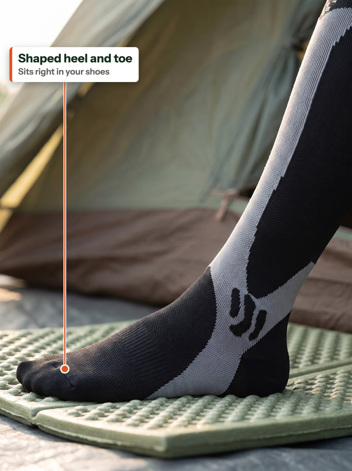 Foot in the compression sock showing the shaped heel and toe (EN label)