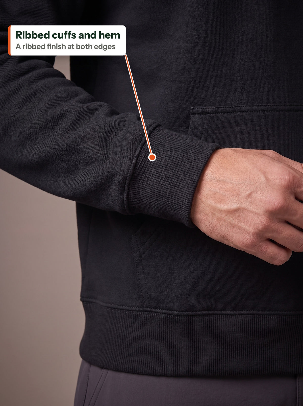 Close-up of the ribbed cuff and hem of the black Fleece Hoodie, labelled Ribbed cuffs and hem