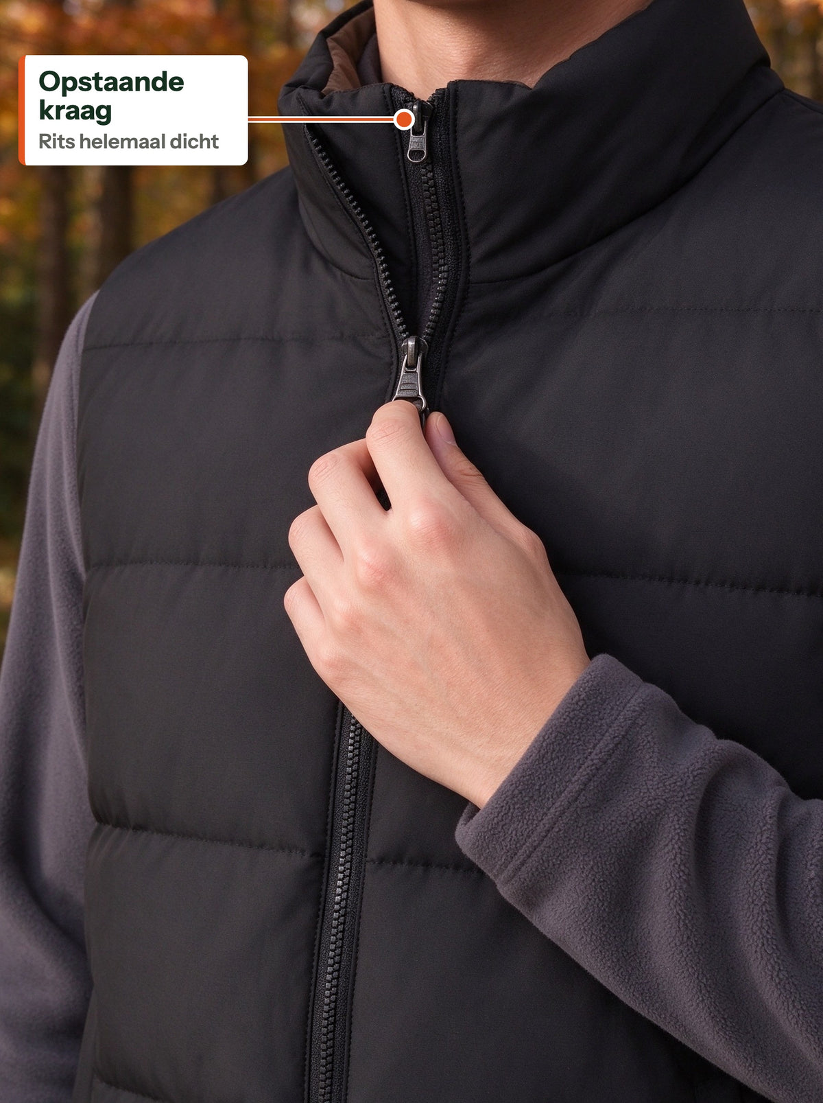Hand zipping the stand-up collar of the black quilted vest (NL label)
