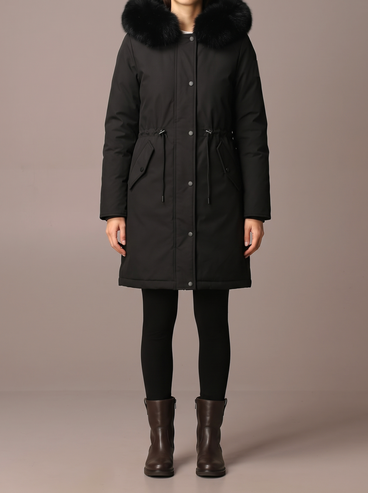 Women's long black parka with black faux-fur hood trim, studio view