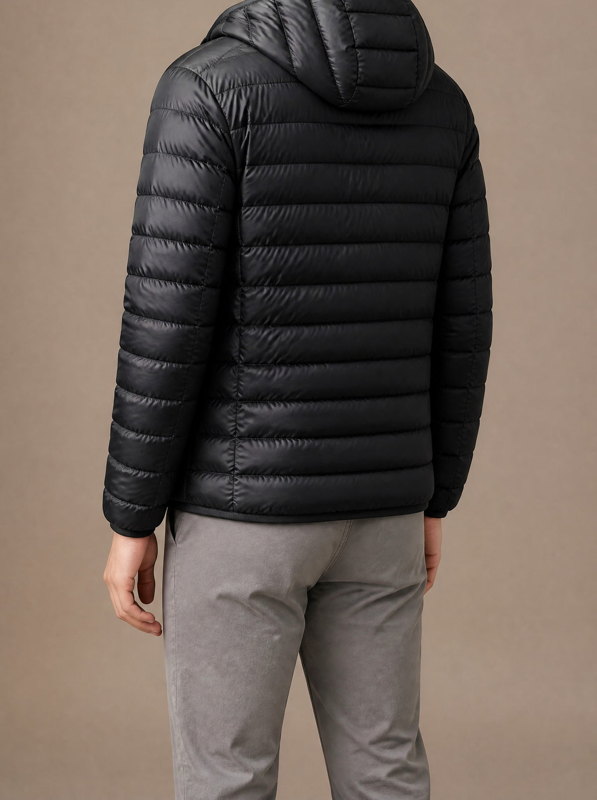 Black packable down jacket from the back, showing the hood, studio view