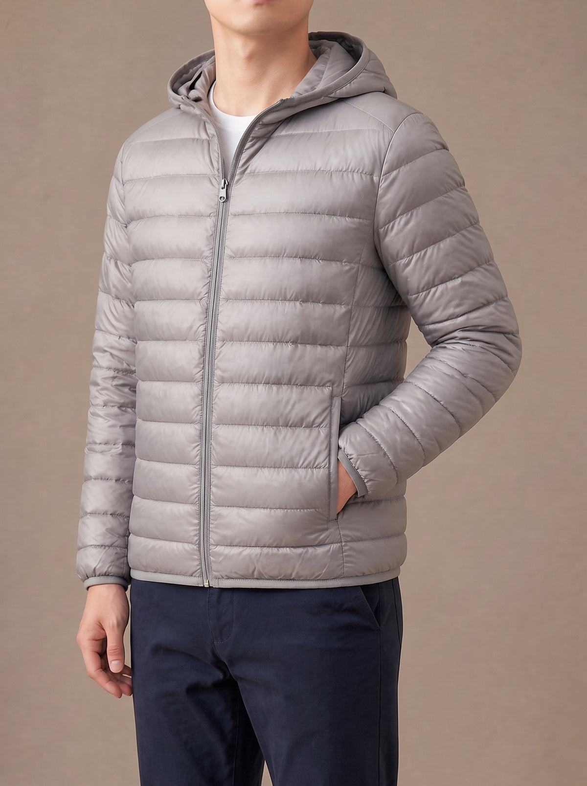 Grey packable down jacket zipped up, hand in the side pocket, studio view