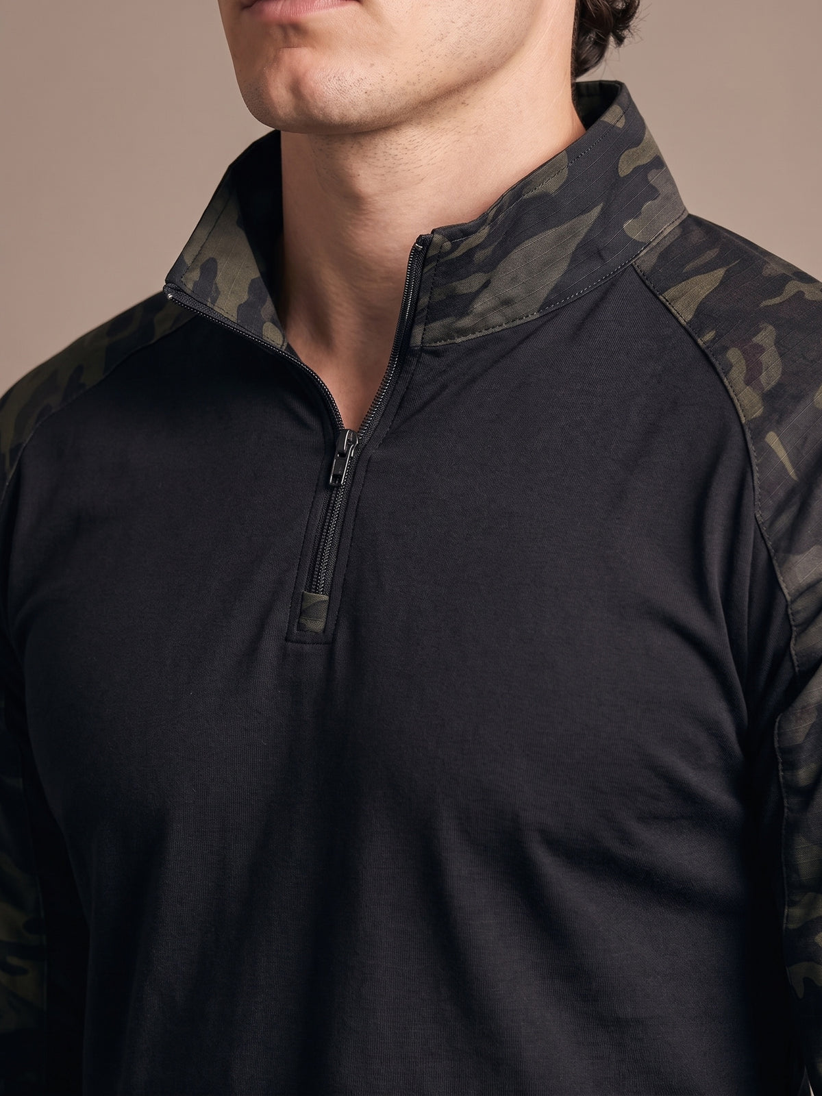 Close view of the quarter-zip collar of the Combat Shirt worn, camo collar meeting the black torso
