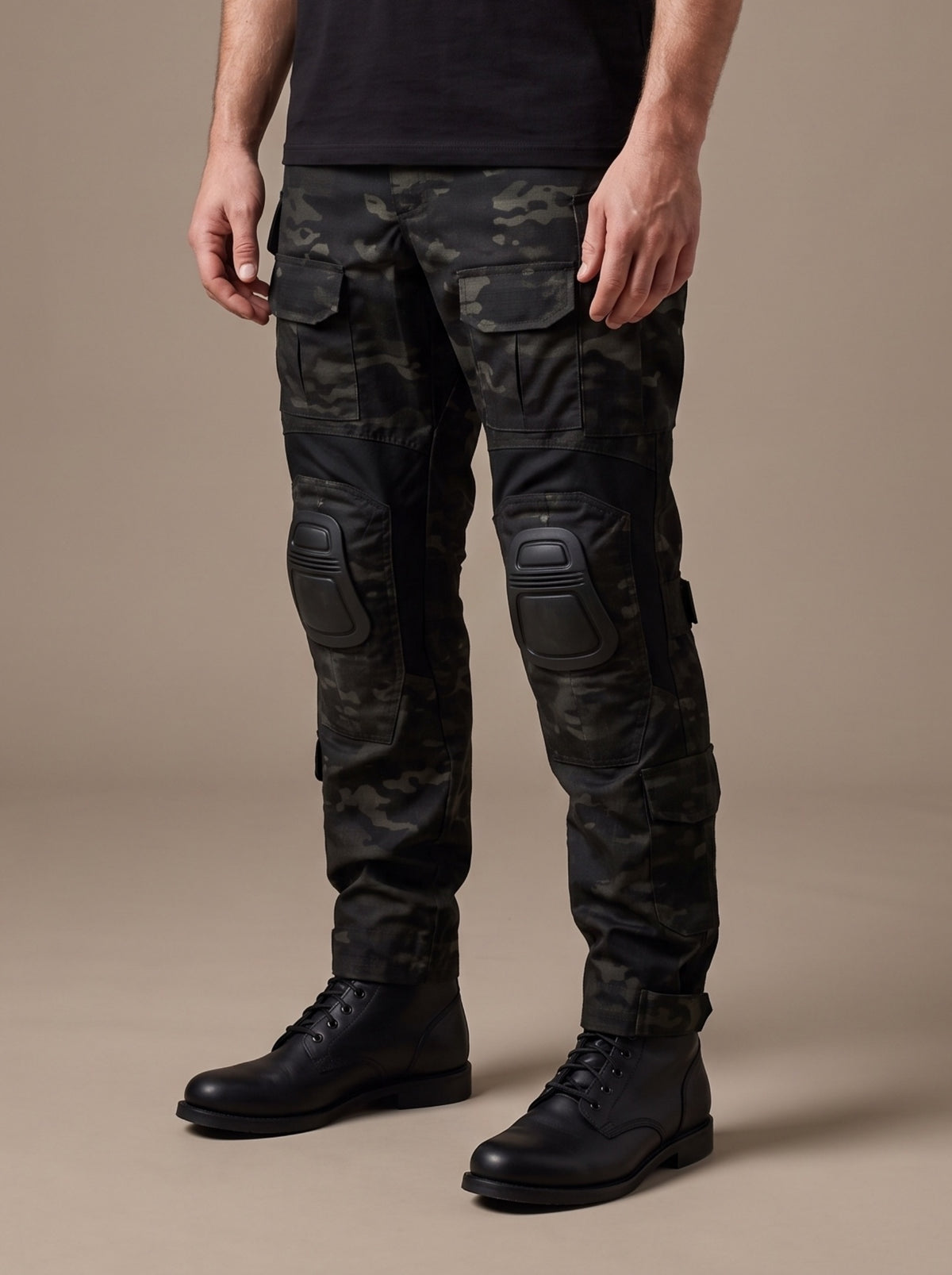 Men's combat trousers with knee pads in Black Camo, worn with a plain black t-shirt, three-quarter view