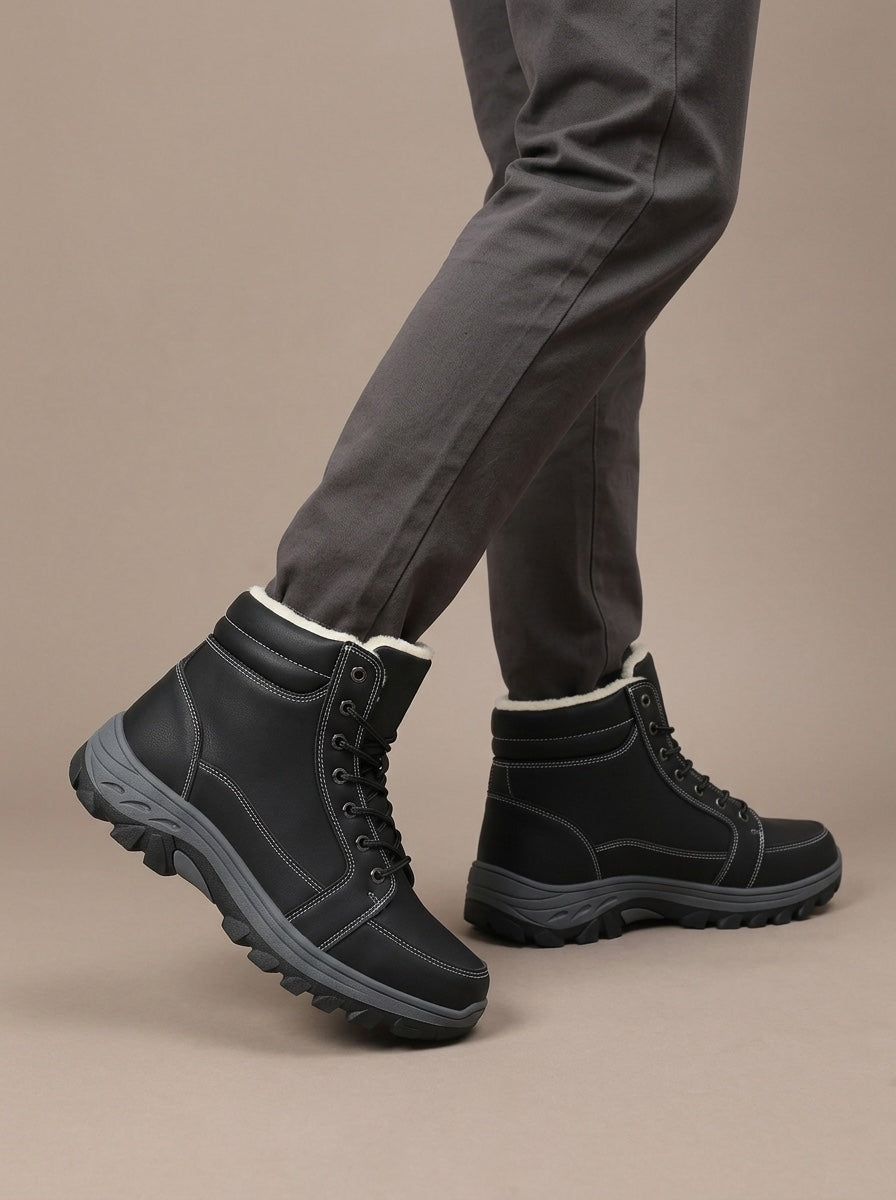 The Lined Field Boot in black with a grey sole, worn, studio