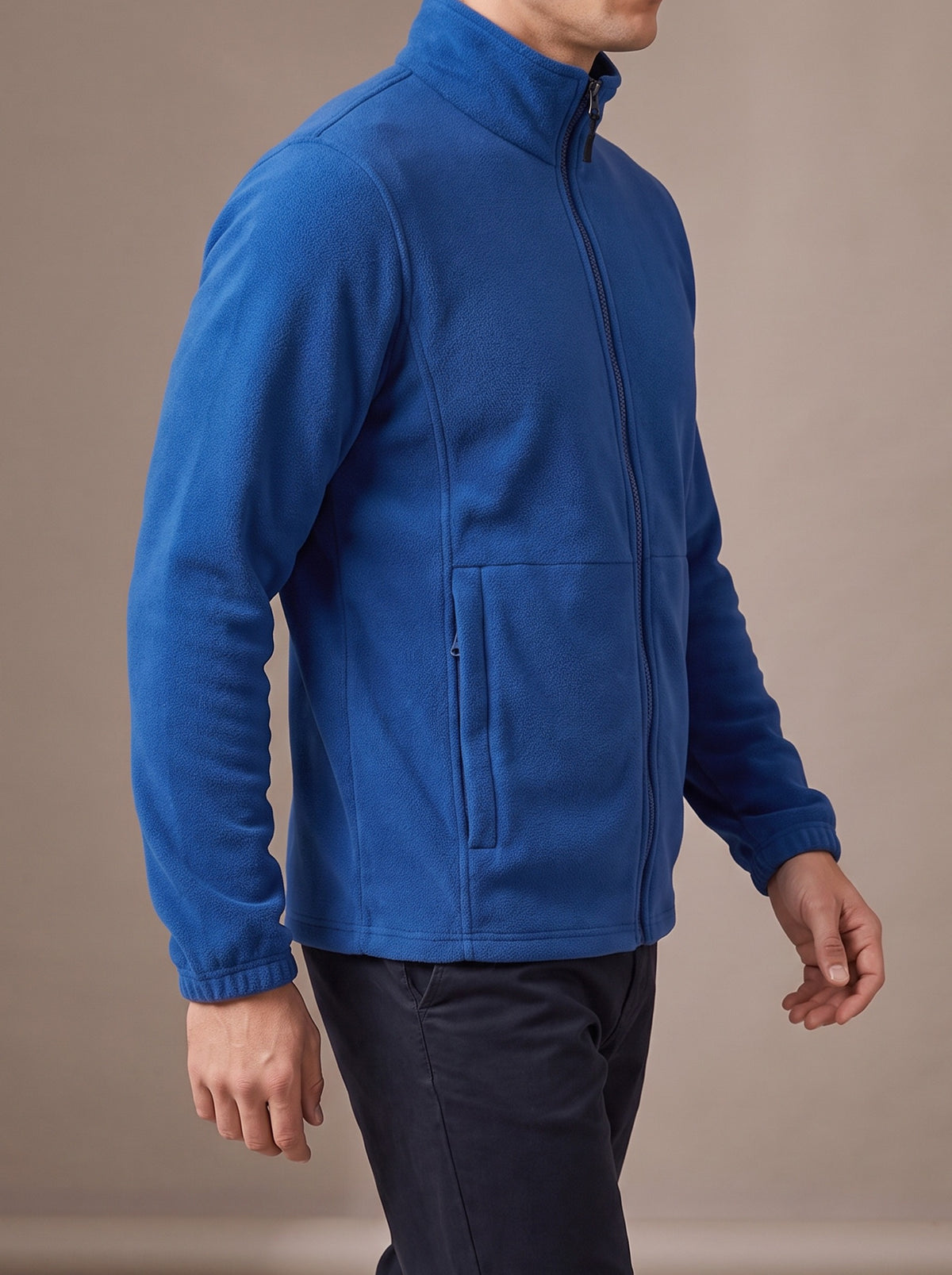 Man walking in the royal blue polar fleece jacket, studio side view