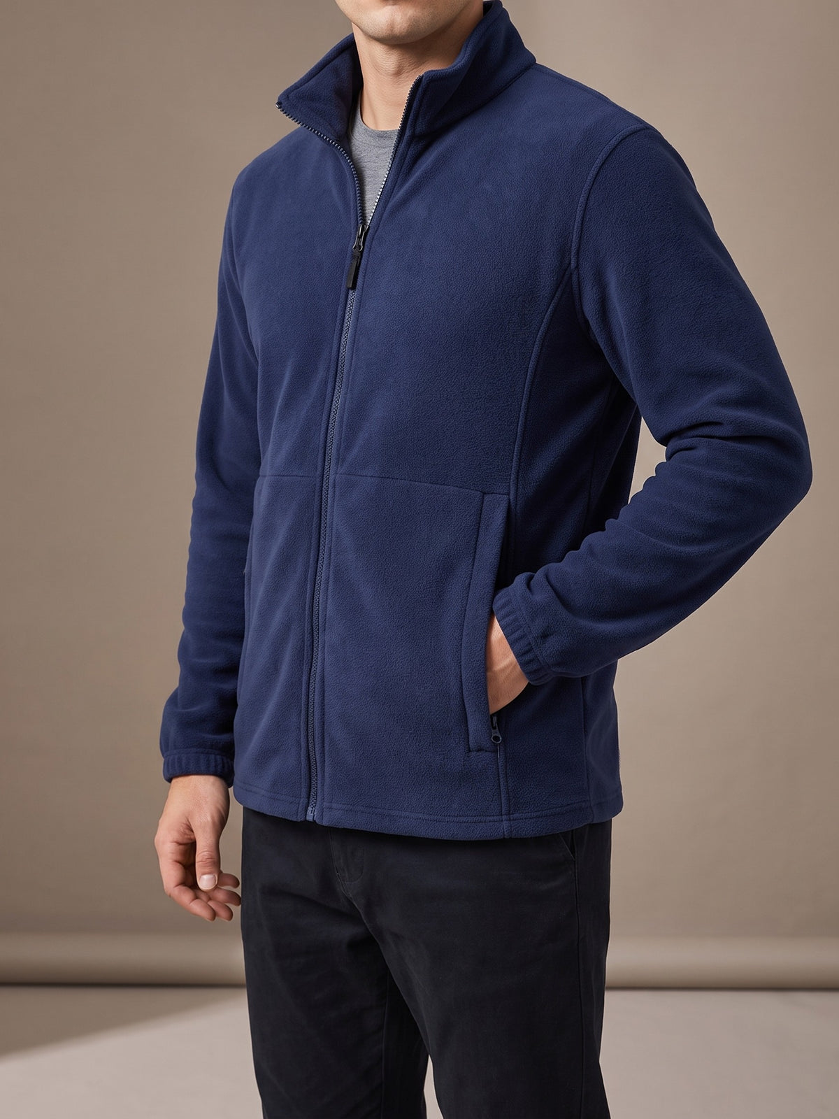 Navy polar fleece jacket with stand collar, full zip and zipped hand pockets, studio front view