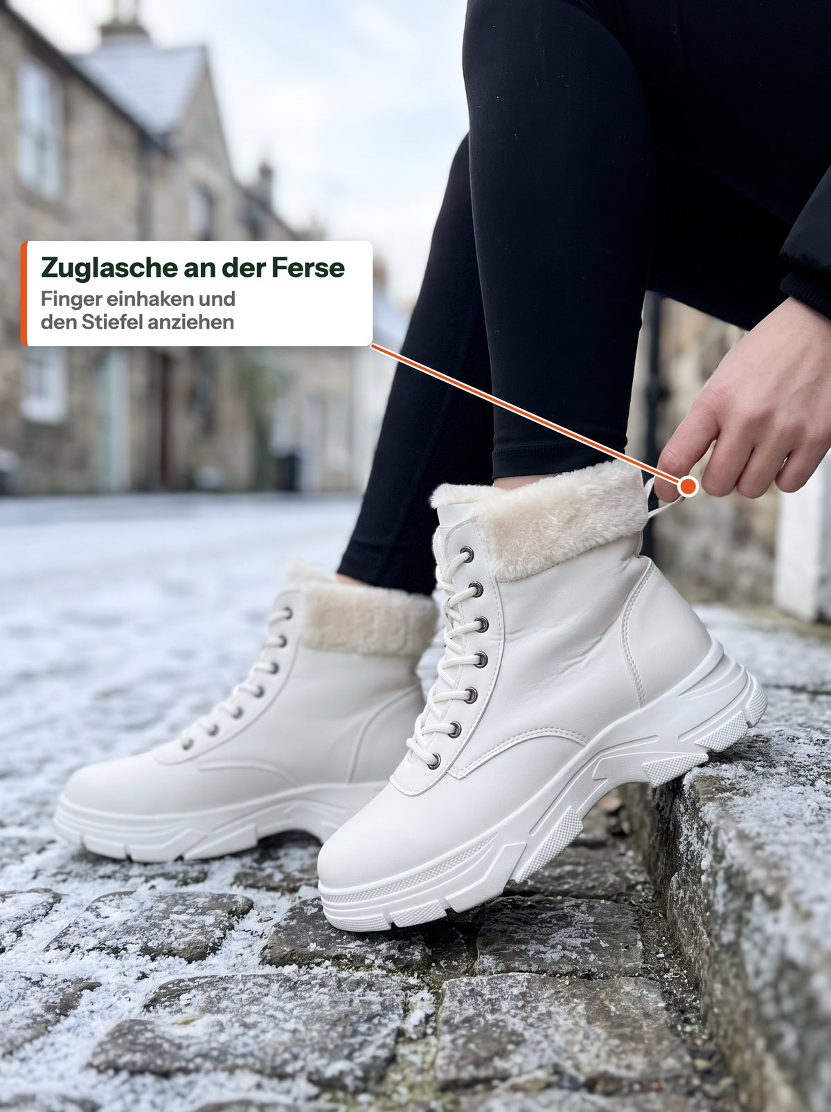 Frau auf einer frostigen Stufe in der Altstadt hakt einen Finger in die Zuglasche an der Ferse des weissen Plush Boot Women (DE Label)