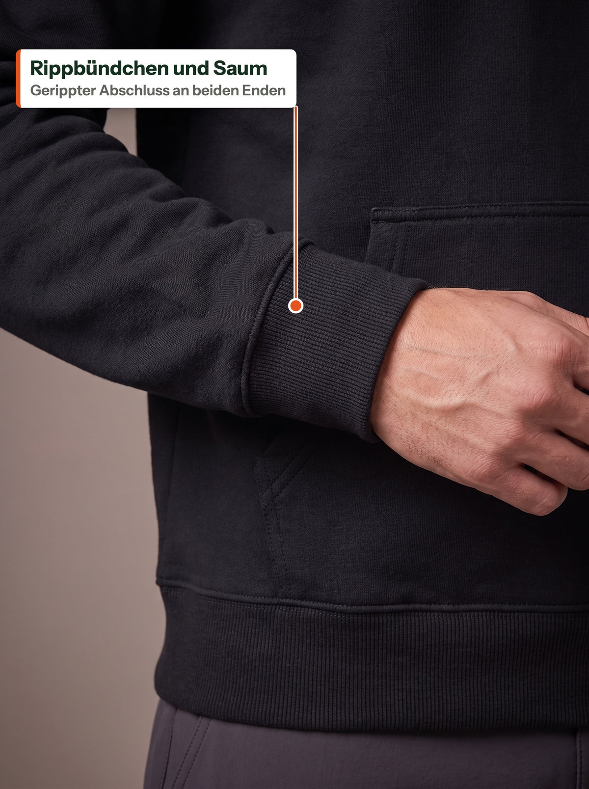 Nahaufnahme von Rippbündchen und Saum des schwarzen Fleece Hoodie, beschriftet Rippbündchen und Saum