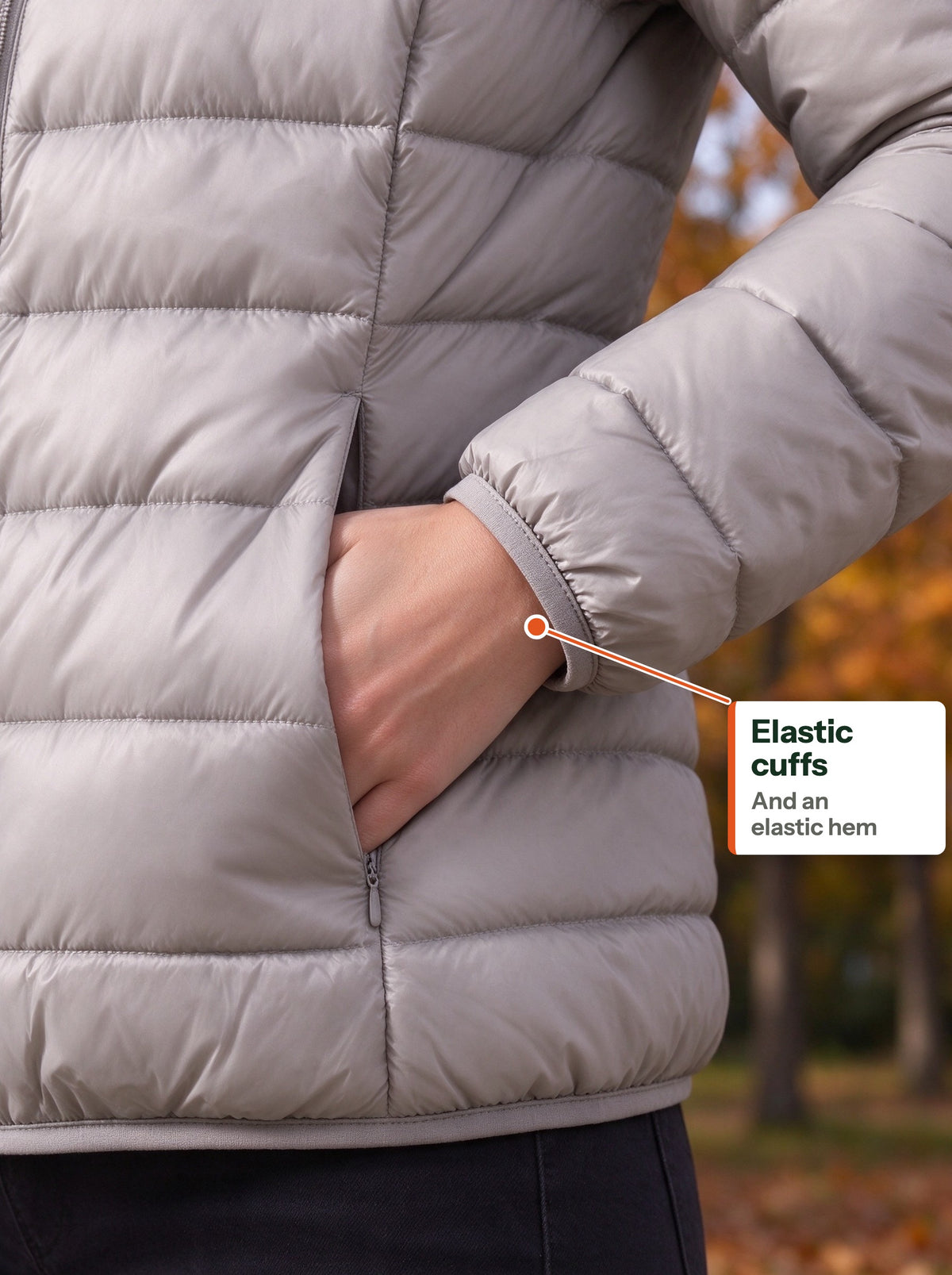 Elastic cuff of the light down jacket around the wrist, hand in the side pocket (EN label)