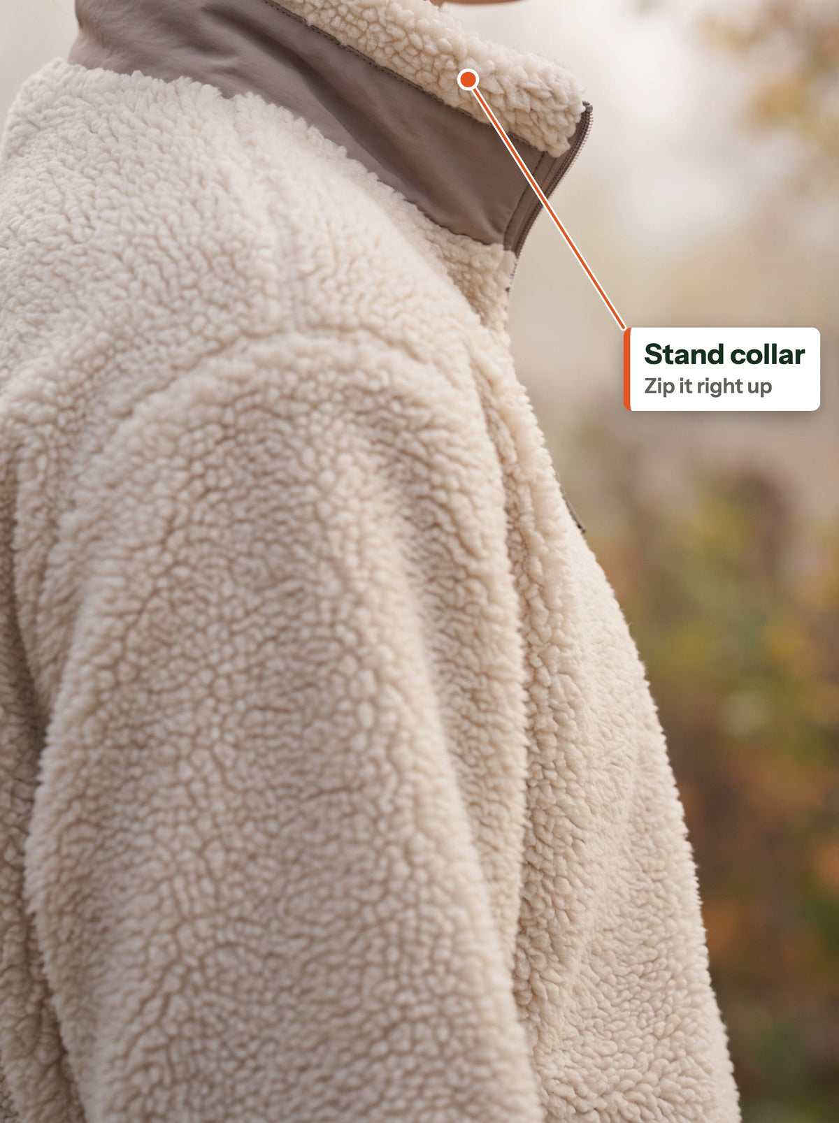 Stand collar of the beige teddy jacket zipped up, seen from the side (EN label)