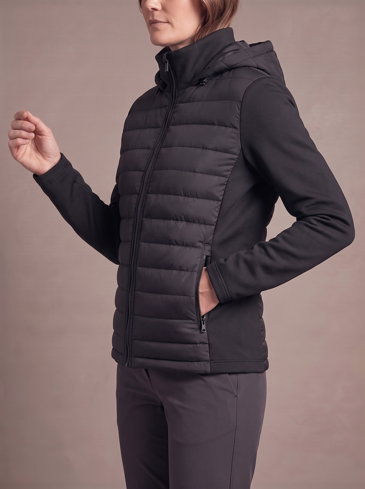 Side view of the black hybrid puffer jacket showing the stretch sleeve, side panel and zip pocket