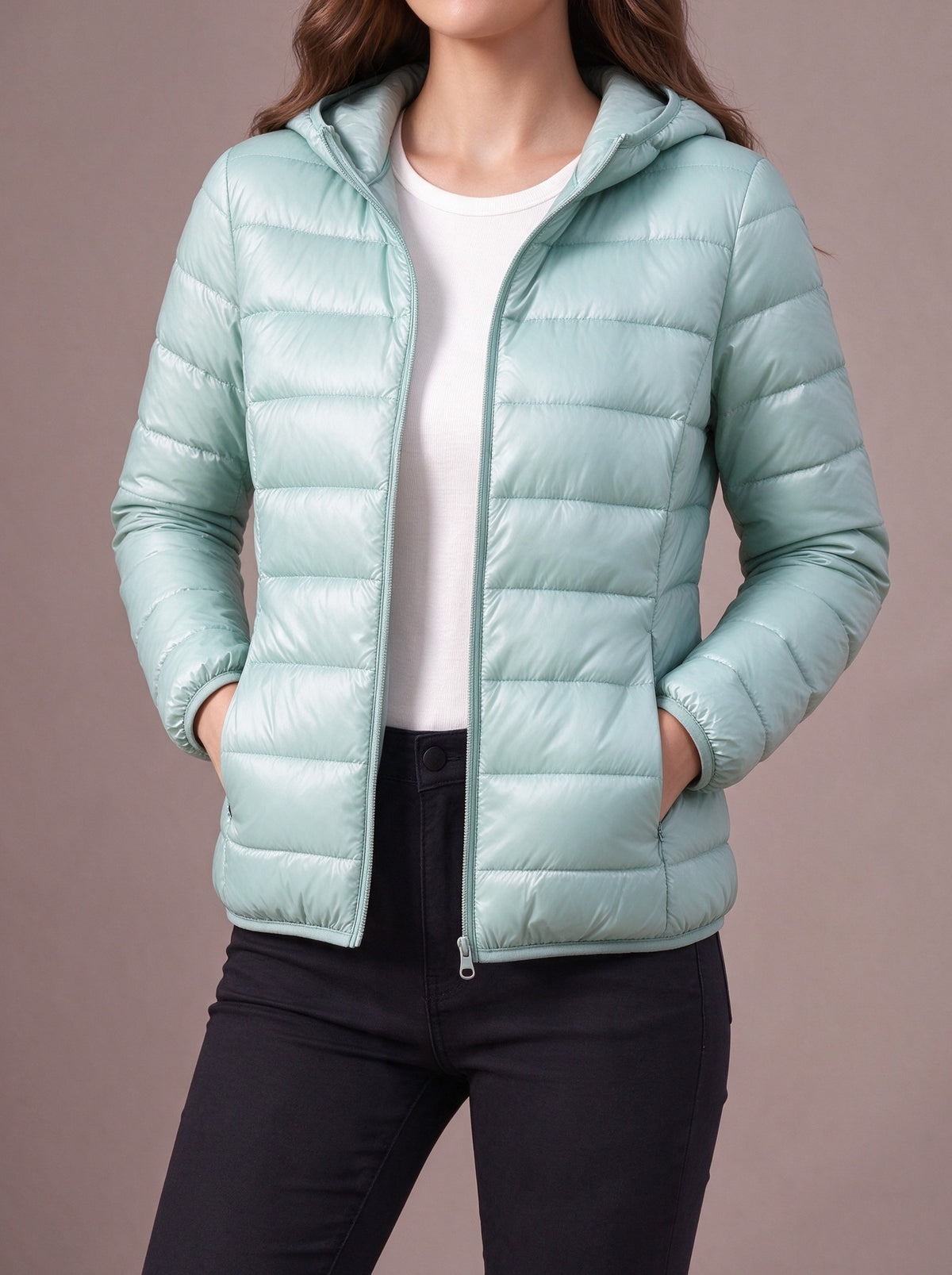Mint light down jacket with attached hood, hands in the side pockets, studio view