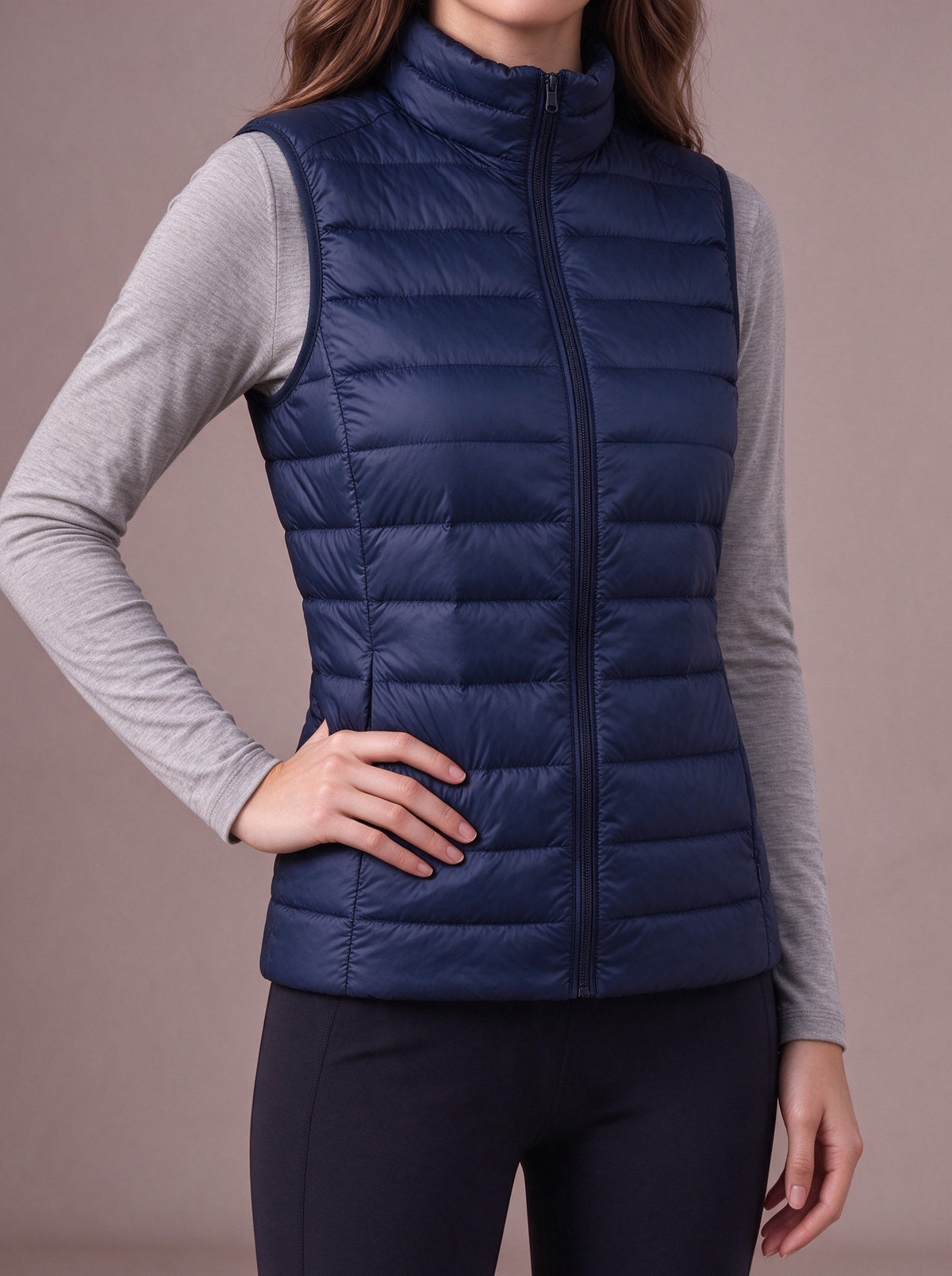 Navy packable down vest, hand on the hip, studio view