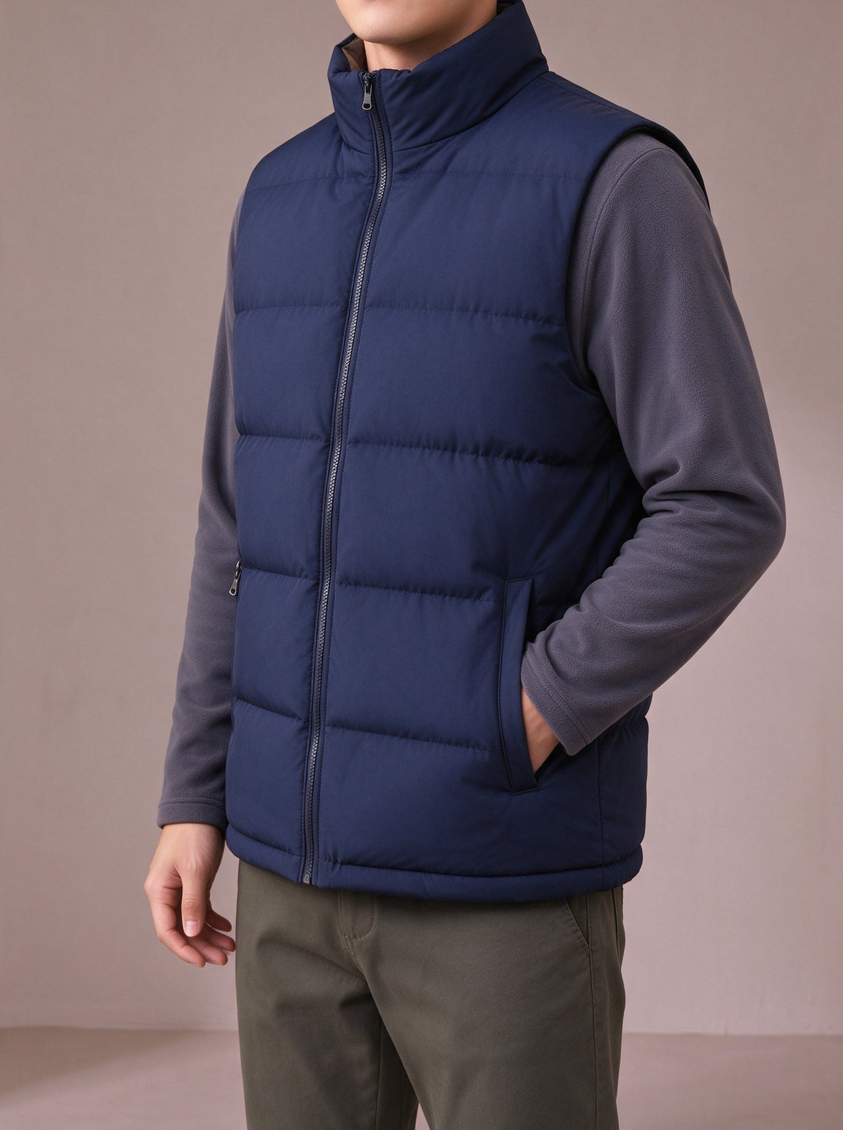 Navy quilted vest, hand in a zipped pocket, studio view