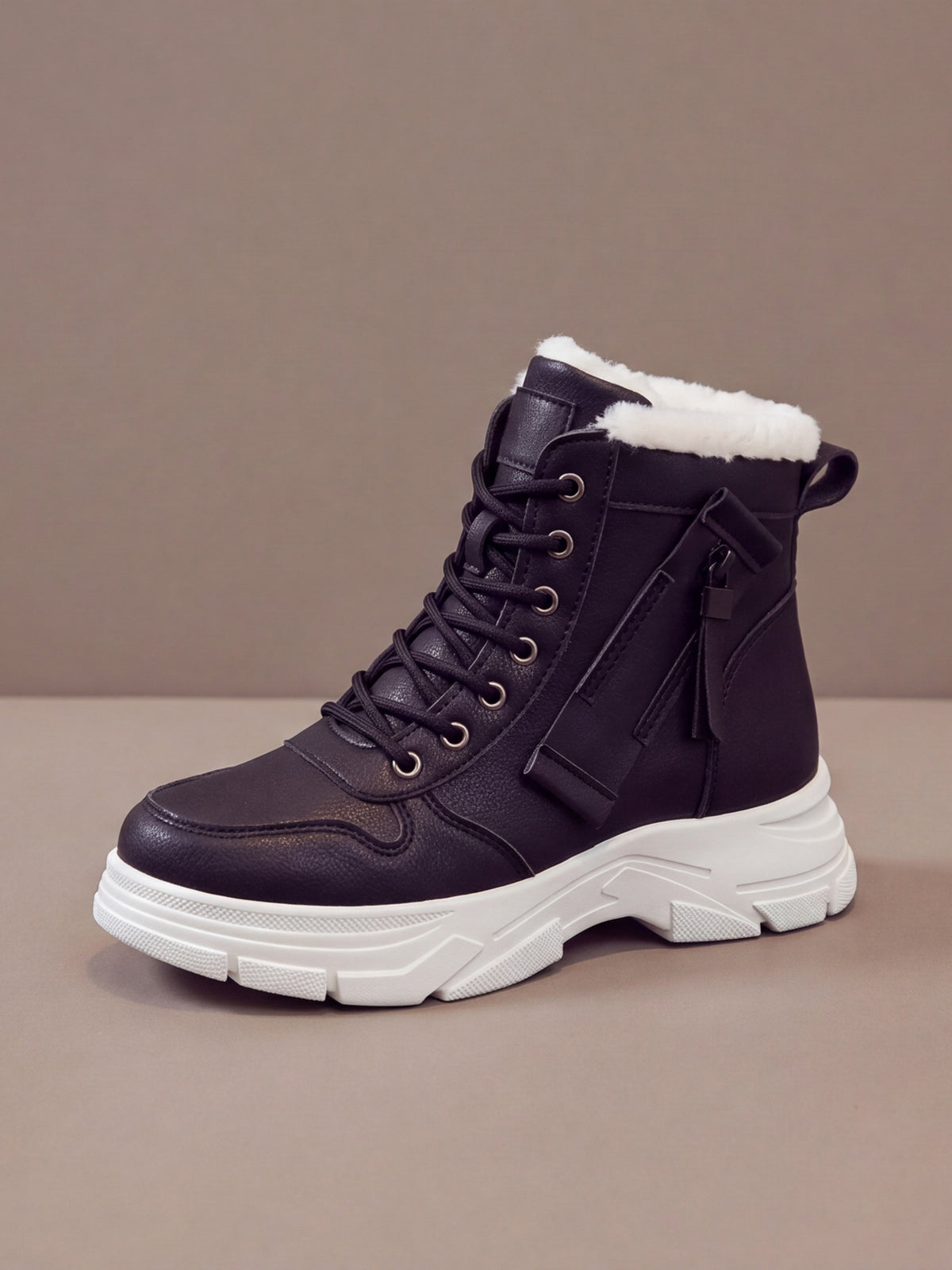 The Plush Boot Women in black with a white sole, studio