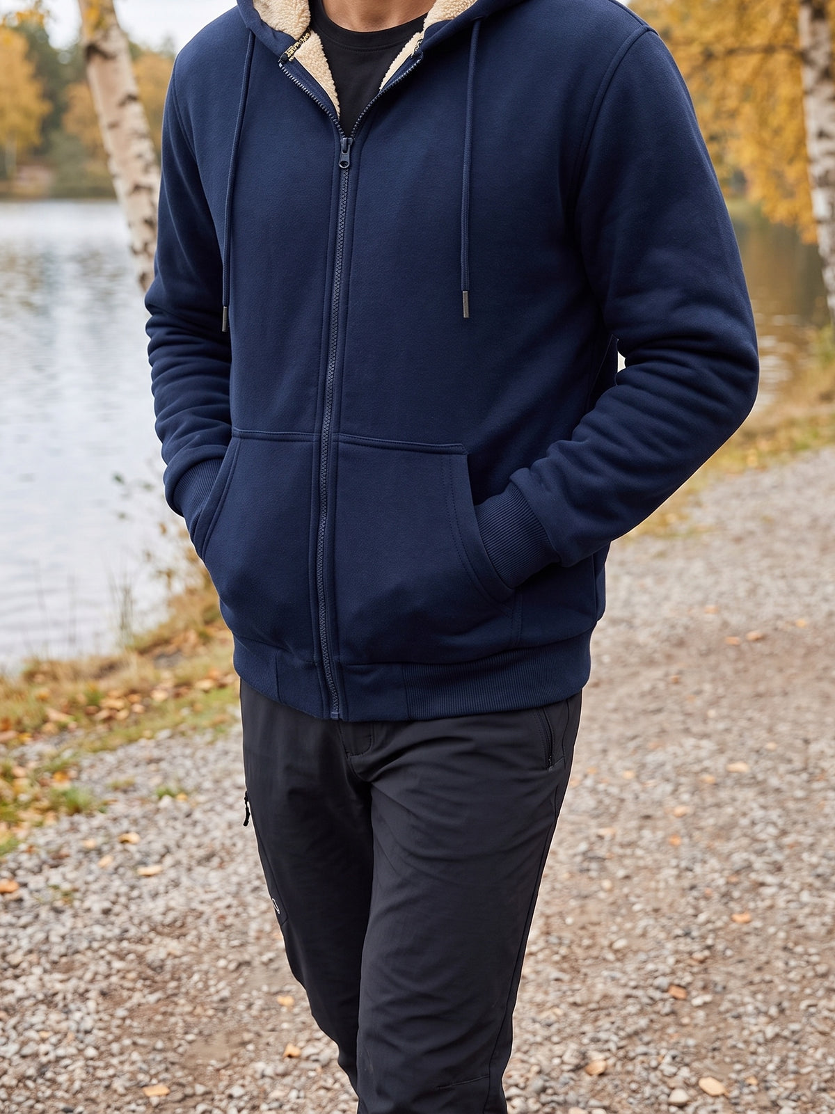 Navy plush-lined zip hoodie worn on a lakeside path in autumn