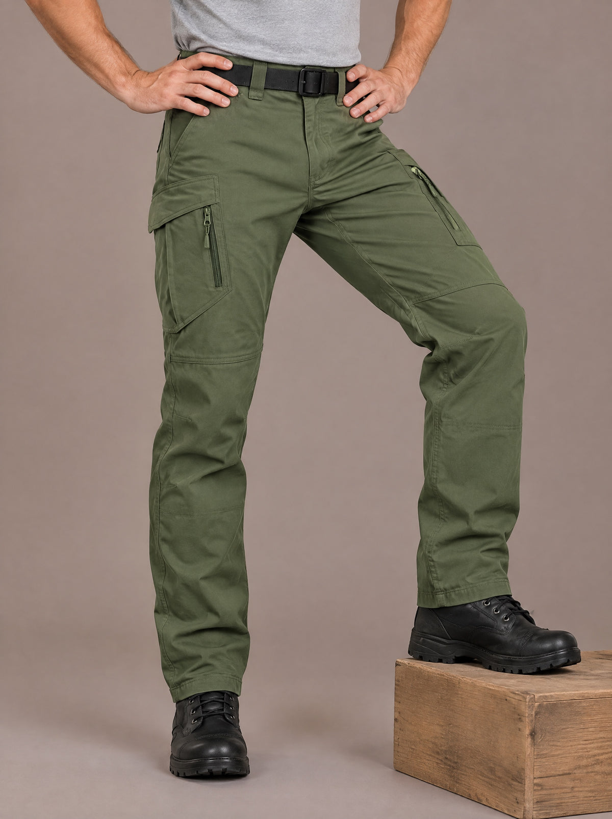 Men's green stretch cotton cargo trousers with zipped thigh pockets, studio view