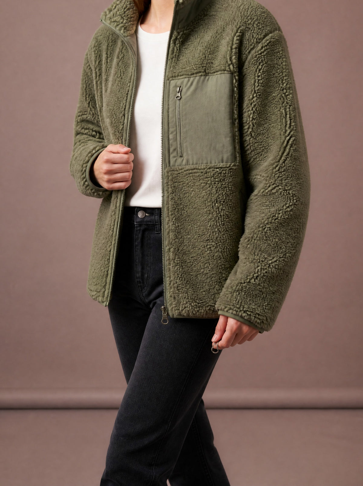 Green teddy fleece jacket worn open over a white top, studio view